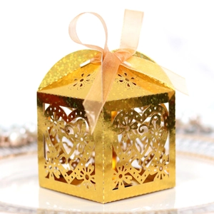 Golden laser-cut heart candy box with intricate floral patterns and an orange ribbon bow