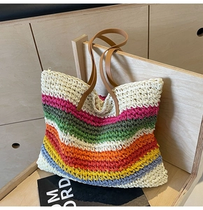 Close-up of rainbow woven tote bag showing colorful stripes and brown leather handle