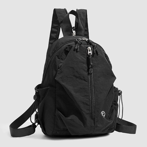 Détail d'un sac à dos en nylon noir avec texture imperméable et fermeture éclair verticale
