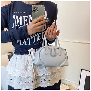 Detailed view of light blue pillow bag with heart buckle and glossy finish