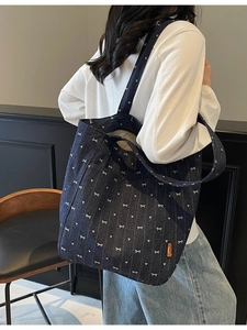 Denim canvas tote bag with white bow heart print shown from back view on model