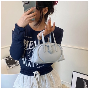 Close-up of light blue heart-shaped handbag in glossy finish with decorative buckle