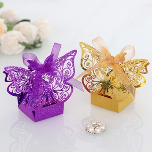 Detail view of laser-cut glitter butterfly gift boxes with elegant satin bows for weddings