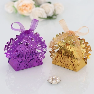 Detail view of laser-cut butterfly gift boxes in purple and gold with ribbon accents