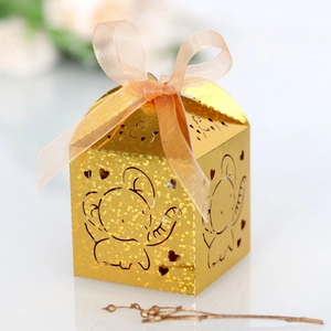 Detail of laser-cut elephant candy box in gold glitter finish with a pink ribbon