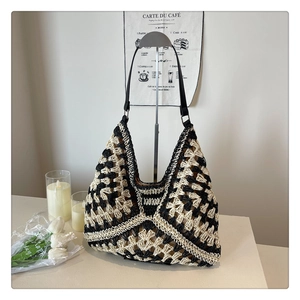 Close-up of crochet knit texture and black leather strap on a woven tote bag