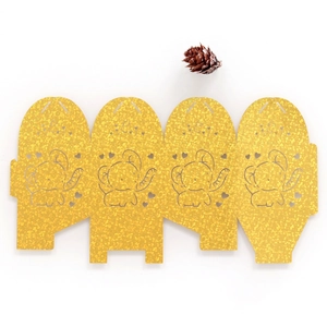 Macro view of laser-cut golden glitter paper wedding candy box with cute elephant detail