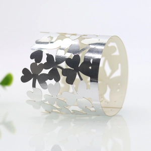 Macro shot of silver mirror-finish napkin ring with four-leaf clover cutout design