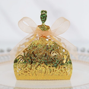 Close-up of glitter gold laser-cut candy box with rose pattern and organza bow