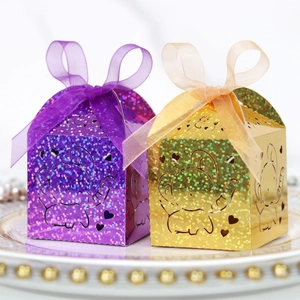 Close-up of laser-cut elephant candy boxes with glitter finish and organza ribbons