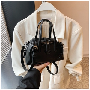 Detailed view of black Boston bag with heart embossing and silver hardware accents