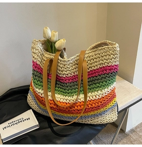 Detail of multi-color woven tote bag with rainbow stripes and brown leather handles