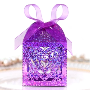 Detail of purple glitter favor box with laser cut heart pattern and satin ribbon bow
