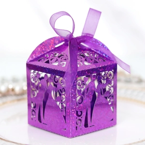 Detail of laser-cut wedding favor box in purple glitter paper with romantic silhouette