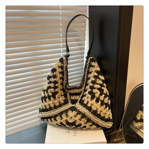 Detailed view of bicolor woven texture and black leather strap on a hobo tote bag