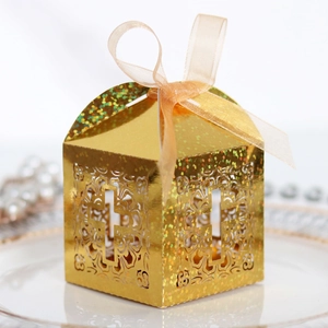 Golden laser-cut wedding favor box with cross pattern and elegant champagne ribbon