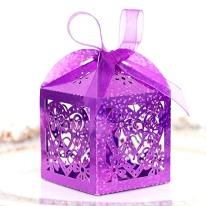 Macro detail of purple glitter laser-cut candy box with heart pattern and ribbon bow