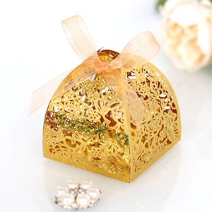 Détail de la boîte à bonbons de mariage dorée découpée au laser avec ruban orange