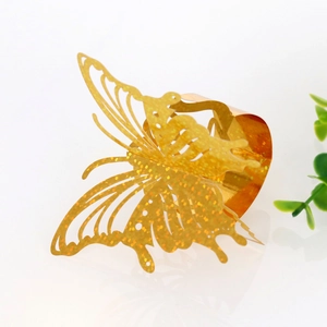 Detailed close-up of golden glitter butterfly napkin ring with laser-cut hollow design