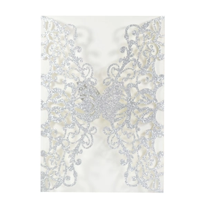 Macro view of silver glitter paper butterfly invitation with laser cut vine pattern