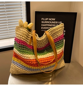 Detail of colorful rainbow striped woven straw tote bag with brown leather handle