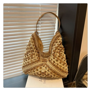 Detail of crochet knit hobo bag featuring geometric patterns and brown leather strap
