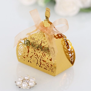 Detailed laser-cut golden dress favor box with glitter finish and pink ribbon detail