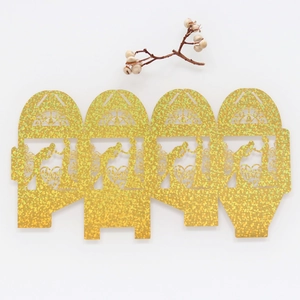 Flat lay of laser-cut gold glitter wedding favor box featuring Thank You heart design