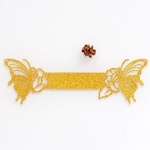 Detailed view of golden glitter laser-cut butterfly napkin ring for wedding decor