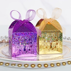 Detailed view of hollowed cross candy boxes with glitter finish and satin ribbons