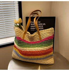 Close-up of colorful rainbow woven stripes and brown faux leather handles on summer tote