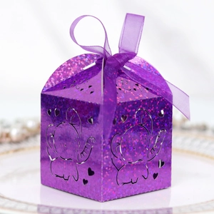 Detail of laser-cut elephant pattern on purple glitter gift box with ribbon