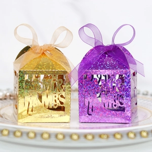 Detail of glitter gold and purple laser-cut candy boxes with Mr & Mrs silhouette and organza bow