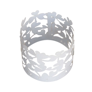 Close-up of laser-cut white pearl paper cupcake wrapper with floral hollow patterns