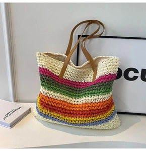 Macro shot of colorful rainbow straw woven texture and brown leather handle on tote bag