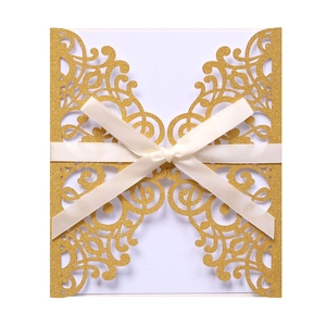 Macro detail of laser-cut hollow pattern on golden glitter wedding invitation with bow