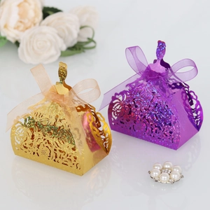 Detailed laser cut favor boxes in princess dress shapes with glitter finish and ribbons