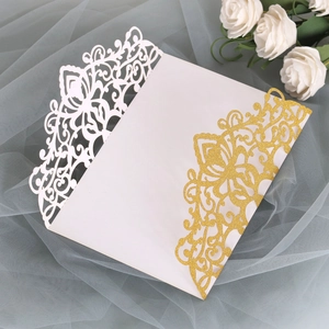 Detail of laser-cut floral wedding invitation with gold glitter and white cardstock