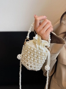 Elegant off-white pearl woven bucket bag with drawstring satin lining and crossbody strap