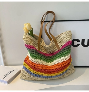 Detail of a woven rainbow straw tote bag with brown leather handles for summer beach trips