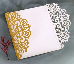 Macro detail of laser-cut hollow pattern on white cardstock with golden glitter accents