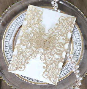 Close-up of elegant laser-cut butterfly invitation with gold glitter and pearl decor