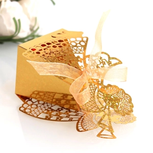 Close-up of golden laser-cut hollow gift box with elegant glitter and sheer ribbon bow
