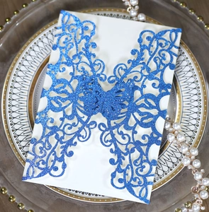 Macro detail of laser-cut glitter navy blue butterfly invitation with pearly texture