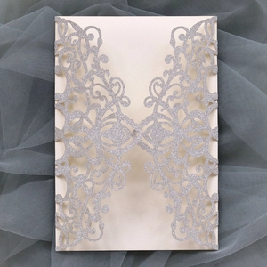 Silver glitter laser cut wedding invitation with intricate floral lace pattern