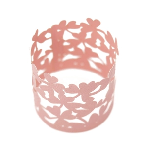 Detail of pink laser-cut cupcake wrappers with intricate floral and butterfly hollow design