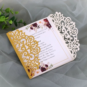 Macro detail of laser-cut glitter invitation with vintage floral print on ivory card