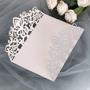 Detailed laser cut lace design with silver glitter on elegant cream card invitation
