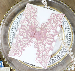 Intricate laser-cut pink glitter wedding invitation cover with elegant vine and butterfly patterns