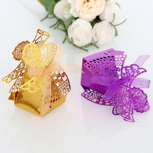 Detail of laser-cut angel gift boxes in gold and purple with elegant ribbon bows